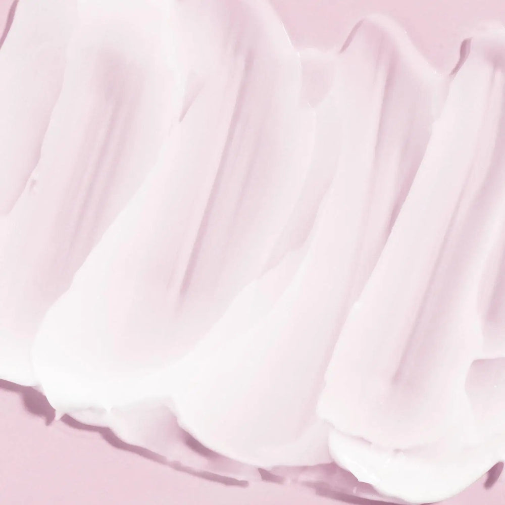A swatch of the AntiBeauty Fragile Calming Cleanser on a pink background, showing its creamy texture and soothing properties for delicate skin.