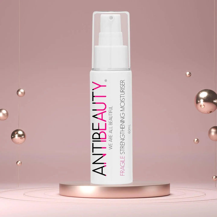 AntiBeauty Fragile Strengthening Moisturiser - a gentle and effective solution for sensitive and ageing skin - on a pastel pink platform background.
