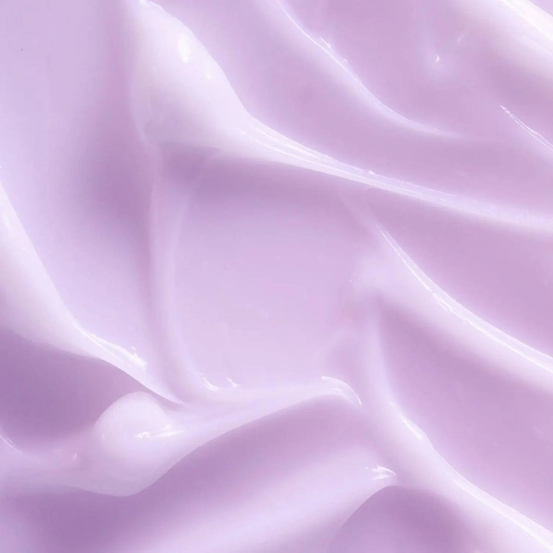 A swatch of the AntiBeauty Fragile Strengthening Moisturiser on a pink background, showing its milky texture and soothing properties for delicate skin.
