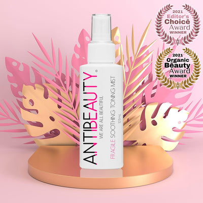 Fragile Soothing Toning Mist on gold platform in front of a pink background with award logos