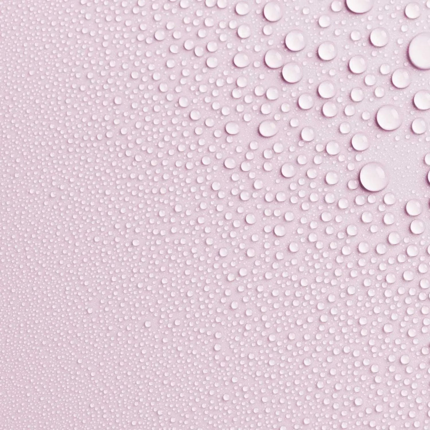 Close-up photo of AntiBeauty Fragile Soothing Toning Mist texture, with fine mist droplets on a pastel pink background.