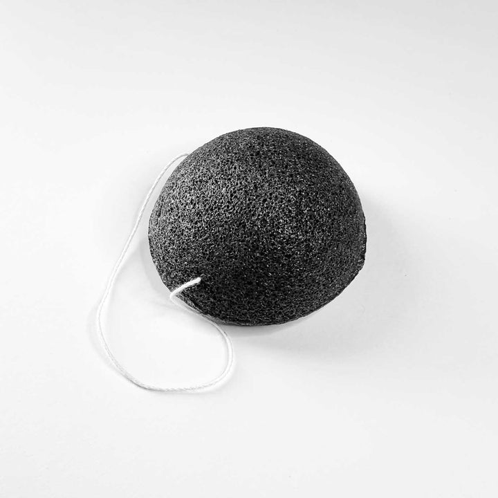 Black AntiBeauty Konjac Sponge on a white background.