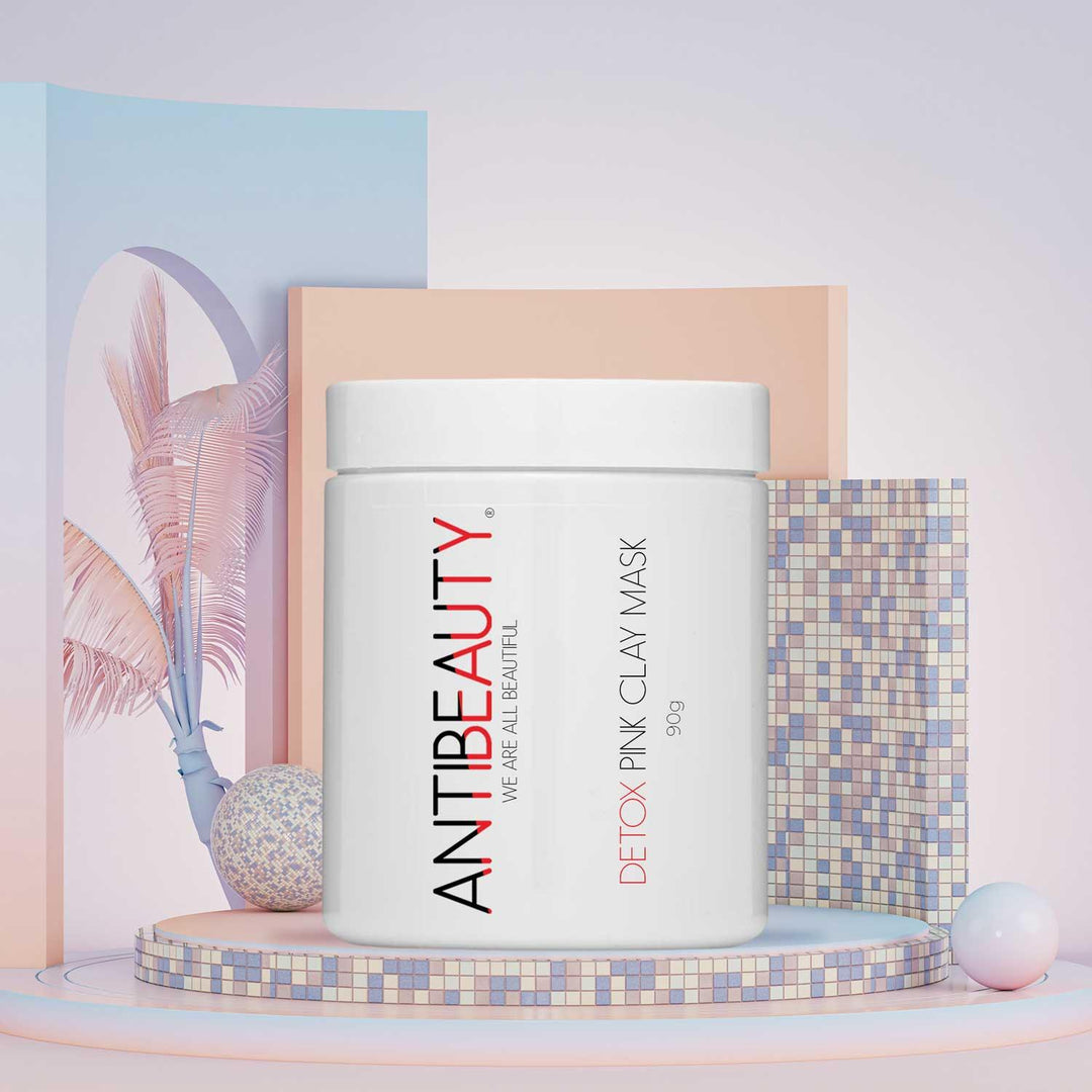 AntiBeauty Detox Pink Clay Mask - a gentle and effective solution for oily or acne prone skin - on a pastel mosaic platform in front of a mixed pastel background. 