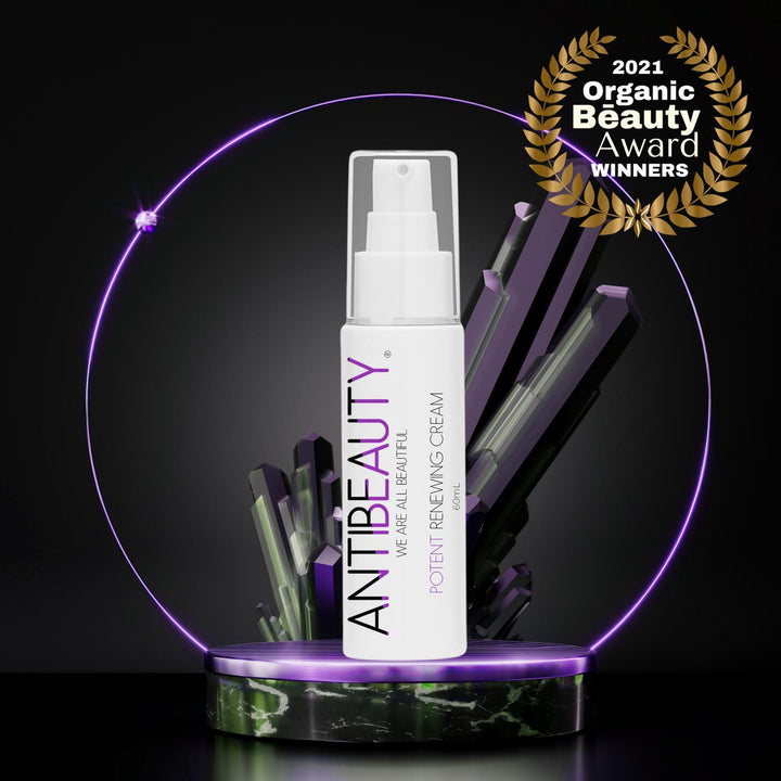 AntiBeauty Potent Renewing Cream Moisturiser - our best seller for mature and ageing skin - on an black podium in front of a black background with purple crystals.