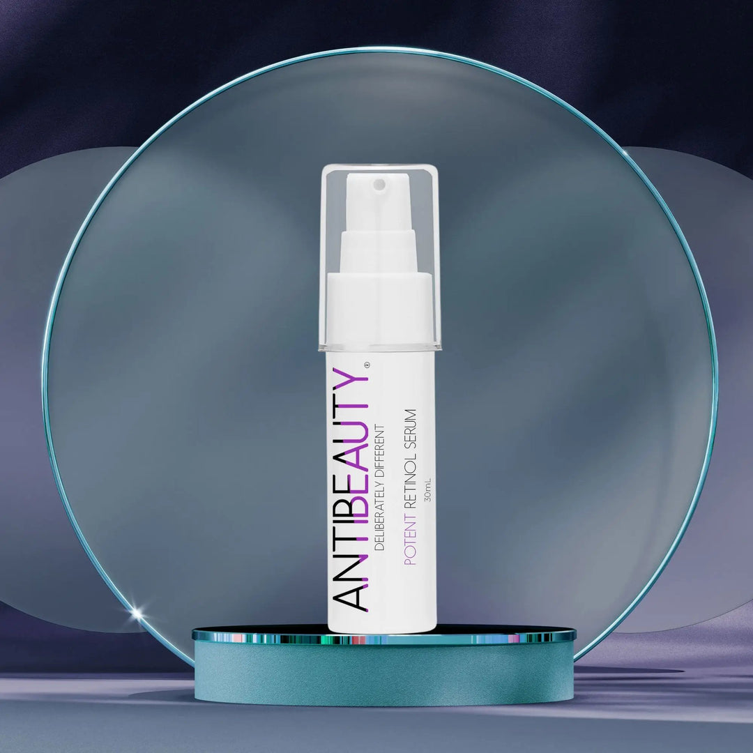 AntiBeauty Potent Retinol Serum - a powerful regenerating serum for all skin - on a blue platform with frosted blue ring background.