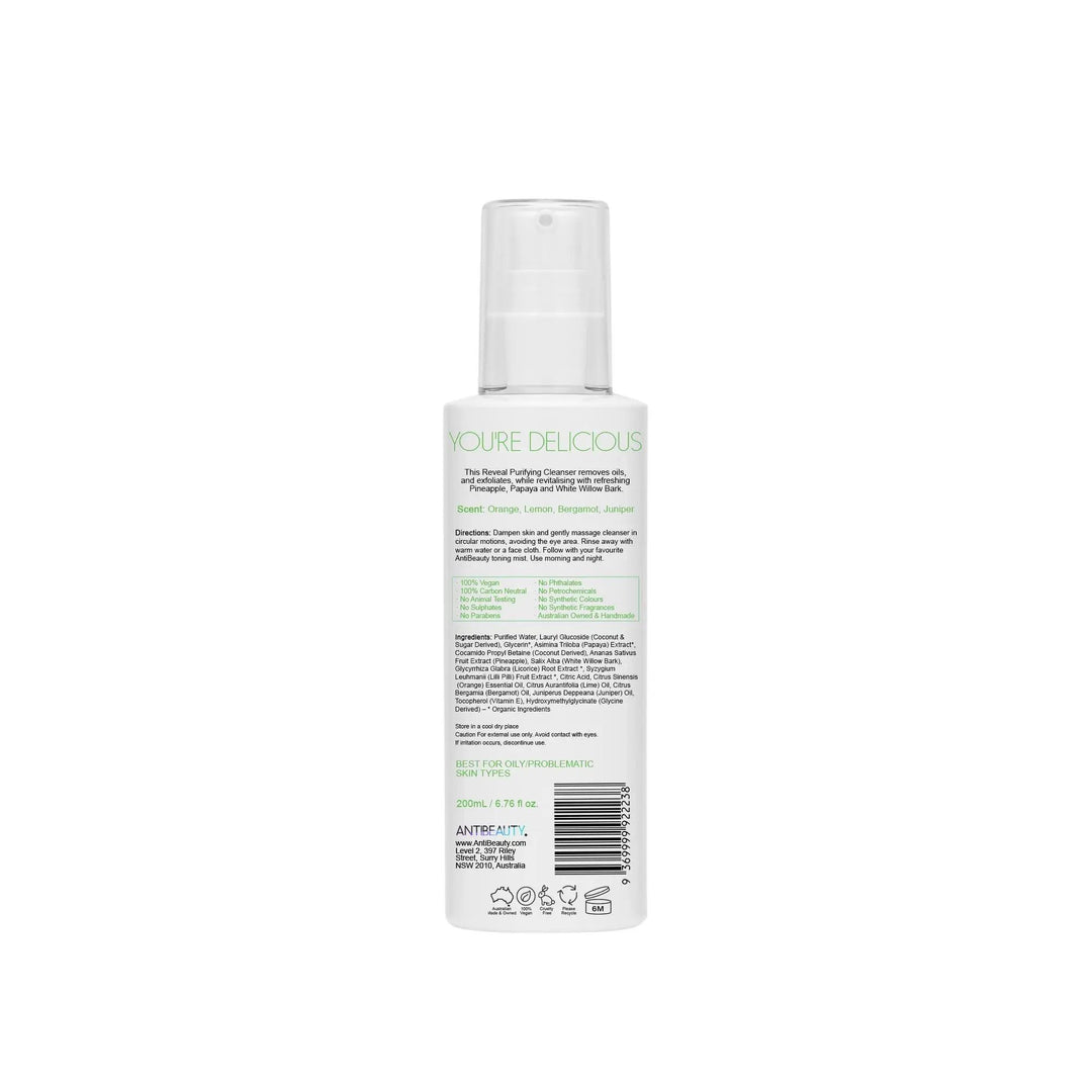 Back label of AntiBeauty Reveal Purifying Cleanser bottle on white background, featuring product details and ingredients list.