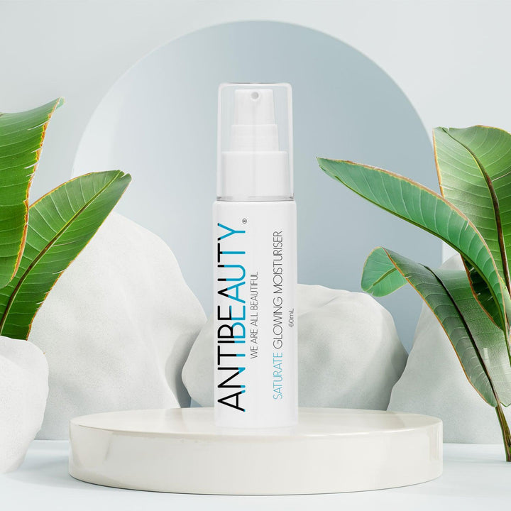 AntiBeauty Saturate Glowing Moisturiser - a gentle and effective solution for normal or dry skin - on a pastel blue platform background.